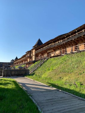 Gökyüzüne karşı tahta kale duvarı. Yüksek duvarları olan ortaçağ kalesi. Eski bir şehir tarzında ahşap döşeme. Park 