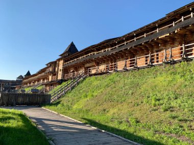 Gökyüzüne karşı tahta kale duvarı. Yüksek duvarları olan ortaçağ kalesi. Eski bir şehir tarzında ahşap döşeme. Park 