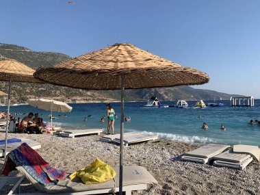 Kumsalda kumsal tatili. Şemsiyeli ve güneşli deniz plajı. Akdeniz 'de yaz tatili. Türkiye 'de Mavi Loguna, Oludeniz - Fetiya, 10 Temmuz 2021