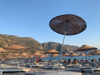 Kumsalda kumsal tatili. Şemsiyeli ve güneşli deniz plajı. Akdeniz 'de yaz tatili. Türkiye 'de Mavi Loguna, Oludeniz - Fetiya, 10 Temmuz 2021
