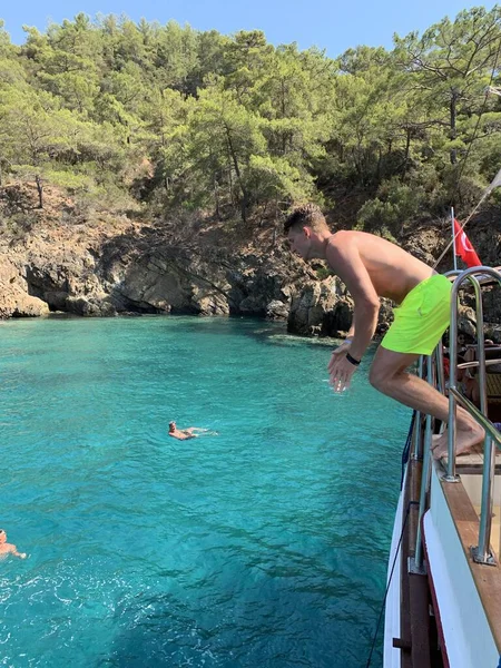 那家伙从船上跳到海里去了 一个人从高处潜入水中 在地中海岩石边游泳 土耳其 Fethia Twelve Islands Tour 2021年7月12日 — 图库照片