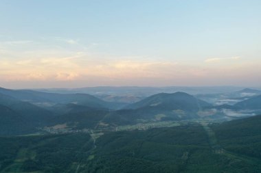 Gün batımında Karpat Dağları 'nın zirveleri. Dağlarda gün batımı, üst manzara. Orman ve dağlar kuş bakışı. Dağ sırası ve yeşil vadi. Varsayılan