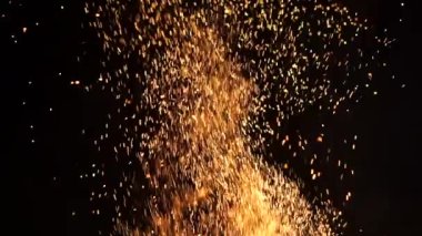 Yangından kıvılcımlar etrafa saçıldı. Karanlıkta ateş dilleri. Siyah arka planda ateş alevi.