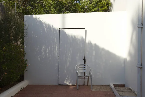 Cadeira Vazia Frente Uma Parede Branca Porta — Fotografia de Stock