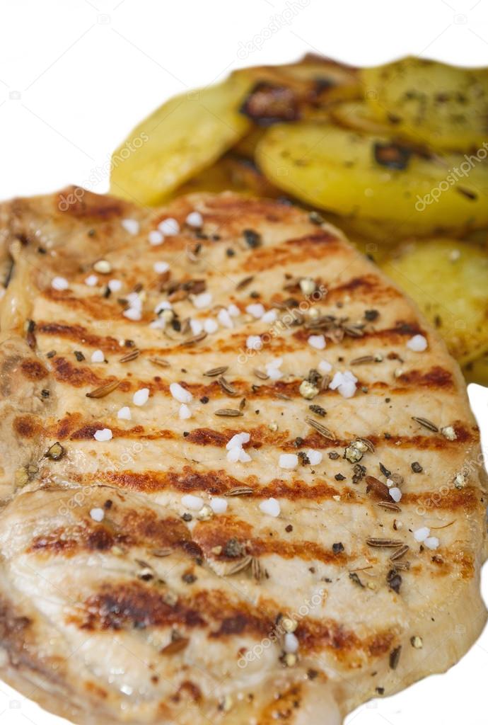 Pork steak with salt pepper and cumin with fried potatoes