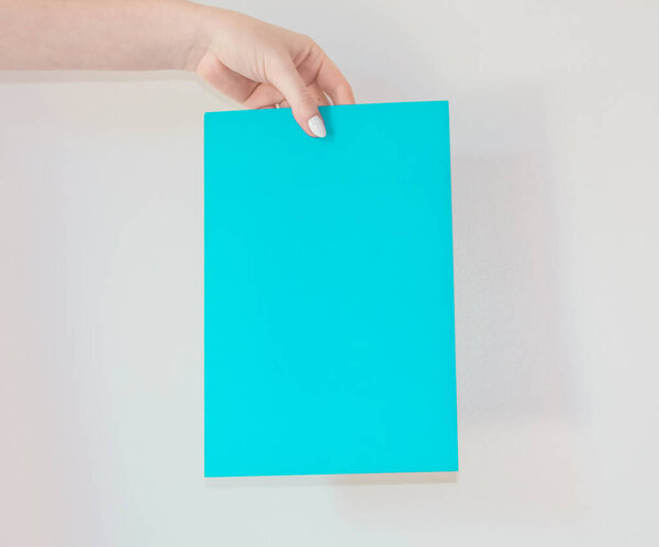 Цветной картон с объявлением в руке молодой девушки с интересной и важной информацией. карточка для надписи.