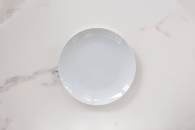 Boş seramik tabağı beyaz mermer arka planda izole edilmiş. Uzayı kopyala Menü Tarifi Kavramı