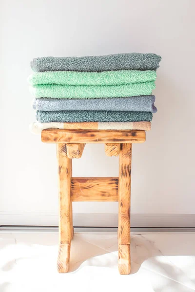 Beaucoup de serviettes de bain colorées empilées les unes sur les autres. Serviettes isolées en coton pour hôtels, maison, salle de bains, cuisine — Photo