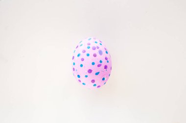  Beyaz bir masada elle süslenmiş şirin bir Paskalya yumurtası. Paskalya tatili konsepti. Güzel benekli yumurta pembe ve mavi.