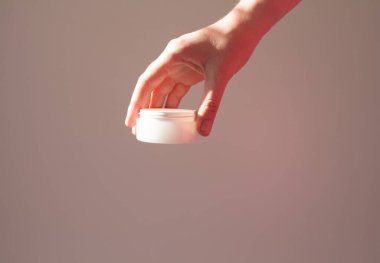  Kadın eli kozmetik ürünleri beyaz bir tüpte tutuyor, yaşlanma önleyici, doğal eko kozmetik ürünler..