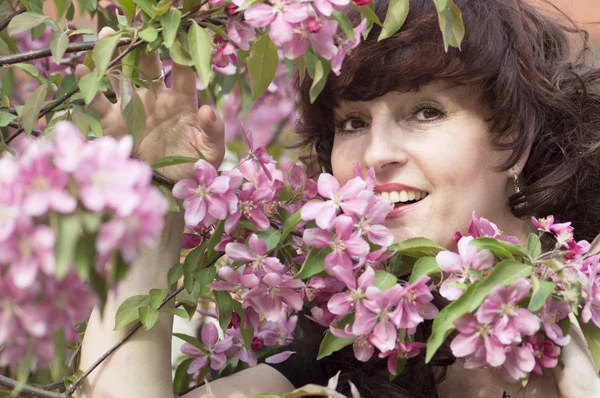 Outdoor Portret van de vrouw van middelbare leeftijd naast een bloeiende app — Stockfoto