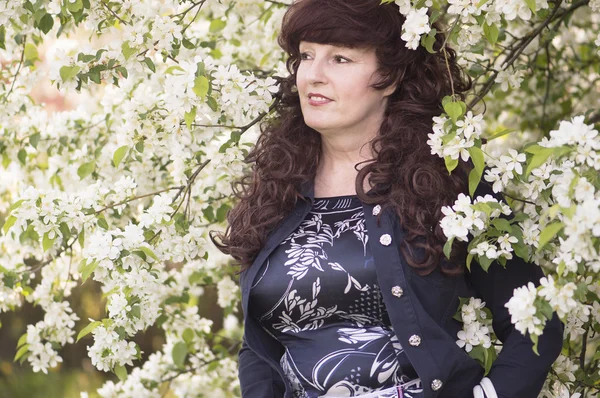 Outdoor Portret van de vrouw van middelbare leeftijd naast een bloeiende app — Stockfoto