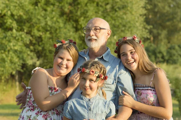 Outdoor portrait of  grandfather with granddaughters. — Stock Photo, Image