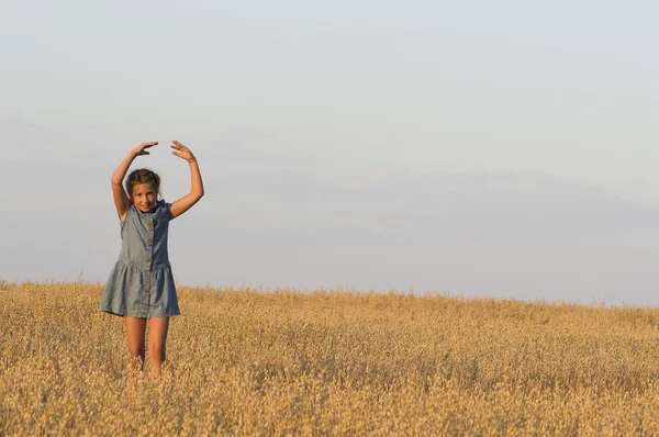 A menina está dançando no campo de aveia . — Fotografia de Stock