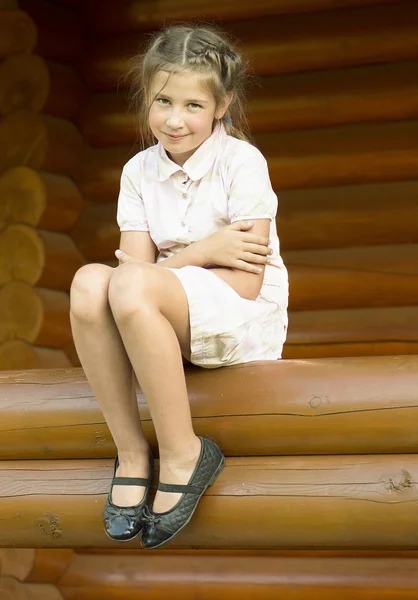 The girl is sittind on a log. — Stock Photo, Image