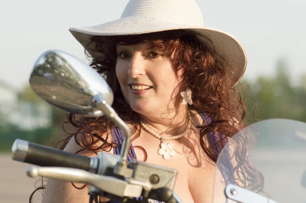 Ritratto all'aperto della donna di mezza età sulla moto . Foto Stock Royalty Free