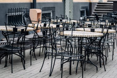 Açık kafedeki boş masalar. Sonbaharda terk edilmiş sokak kafesi.