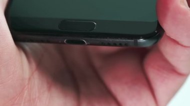 El, USB-C kablosunu şarj etmek için akıllı telefona yerleştirir. Yakın plan - USB kablosu ve bağlantı aracı.