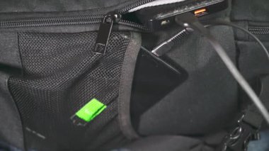 Akıllı telefon şarj oluyor. Cep telefonu sırt çantasındaki bir güç bankasından şarj edilir..