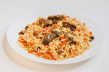 Kızarmış kuzu pirinçli. Beyaz tabakta taze Özbek pilavı. POV