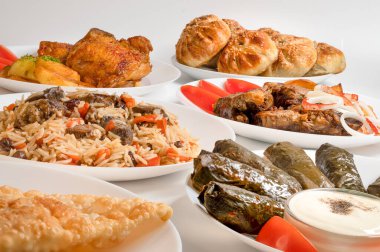 Kazan kebabı, Plov, Dolma ve kızarmış tavuk. Özbek ana yemekleri beyaz tabaklarda. 