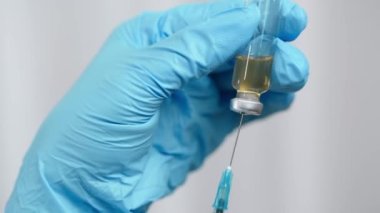 Hemşire ya da doktor elleri şırıngayı aşıyla dolduruyor. Şırıngaya odaklan.