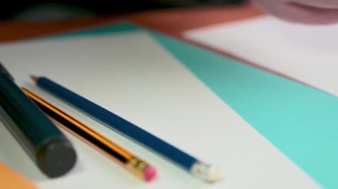 Eli eliyle masadan bir kalem alır ve çizmeye başlar. İş yerinde tasarımcı.