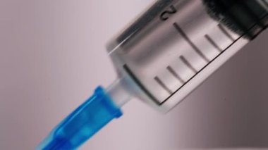 İğne ve aşı yapan bir hemşirenin, iğne ve uyuşturucu içeren bir şırınganın yakın çekimi..