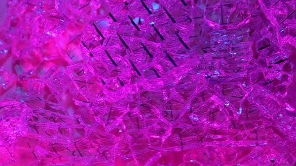 碎玻璃特写 紫光下旋转的碎玻璃堆 — 图库视频影像