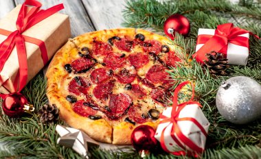 Salamlı Noel pizzası, mozzarella, zeytin, Provencal otlar, markalı domates sosu, Noel süslemeleri, hediyeler, ladin, oyuncaklar.
