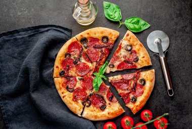 Akdeniz pizzası, salamlı sosis, mozarella, zeytin, Provencal otlar, arka planda imzalı domates sosu.