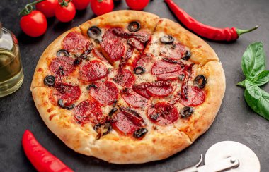 Akdeniz pizzası, salamlı sosis, mozarella, zeytin, Provencal otlar, arka planda imzalı domates sosu.