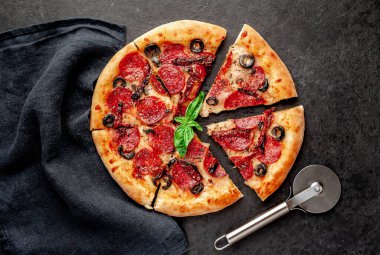 Akdeniz pizzası, salamlı sosis, mozarella, zeytin, Provencal otlar, arka planda imzalı domates sosu.