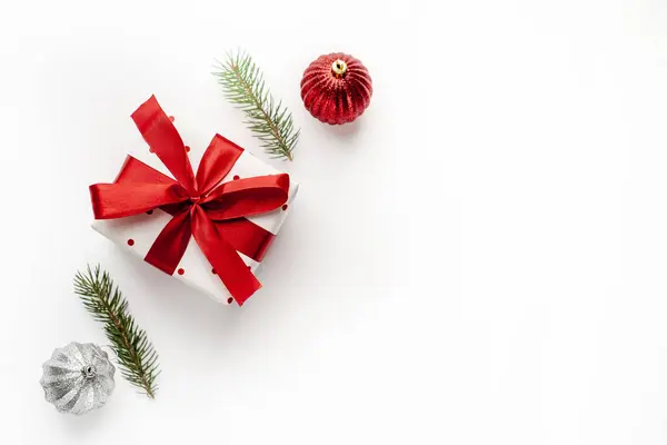 Karácsonyi Kompozíció Fehér Háttérrel Fehér Ajándékdobozzal Vörös Szalaggal Fenyőágakkal Játékokkal — Stock Fotó