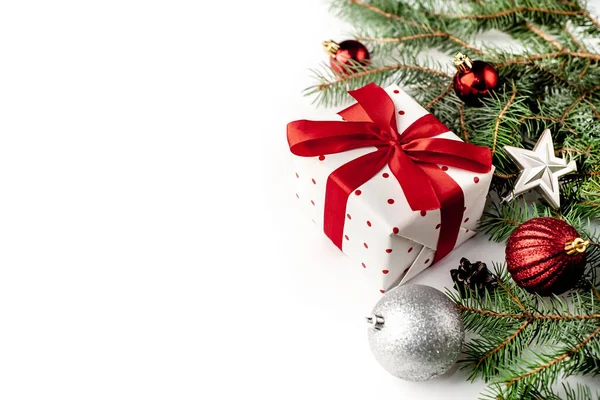 白い背景に白いギフトボックスに赤いリボンとクリスマスの構図モミの枝 おもちゃ おめでとうございます — ストック写真