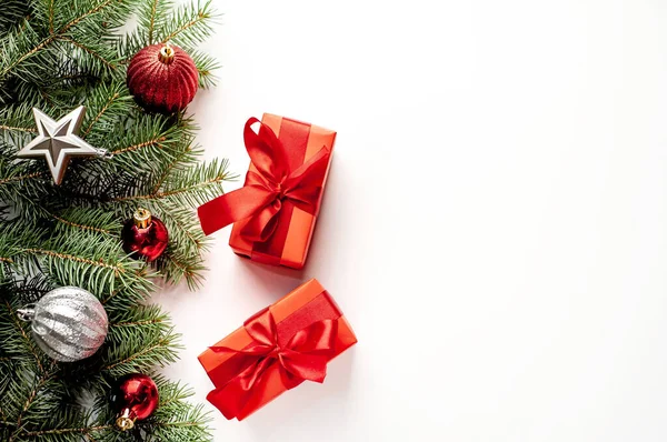 Karácsonyi Kompozíció Fehér Háttérrel Fehér Ajándékdobozokkal Piros Szalaggal Fenyőágakkal Játékokkal — Stock Fotó