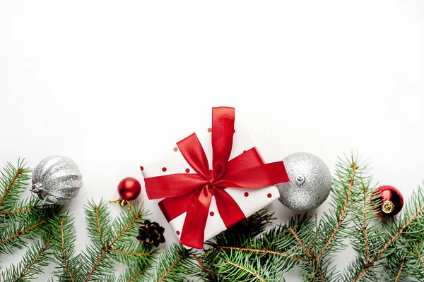 Karácsonyi Kompozíció Fehér Háttérrel Fehér Ajándékdobozzal Vörös Szalaggal Fenyőágakkal Játékokkal — Stock Fotó