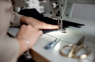 Dikiş makinesine dikiş diken kadın ellerini kapat. Tasarım stüdyosu, terzilik süreci kavramı