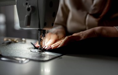 Dikiş makinesine dikiş diken kadın ellerini kapat. Tasarım stüdyosu, terzilik süreci kavramı