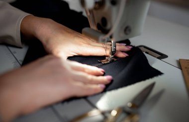 Dikiş makinesine dikiş diken kadın ellerini kapat. Tasarım stüdyosu, terzilik süreci kavramı