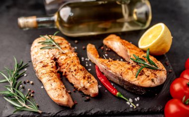 İki kişilik yemek, somon bifteği ve şarap için bardaklar..