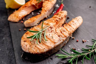 İki kişilik yemek, arka planda somon bifteği..