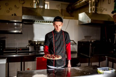 Aşçının mutfakta pizza yapması, yemek pişirme konsepti.