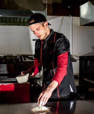 Mutfakta pizza için hamur yapan şefin manzarası, yemek pişirme konsepti.