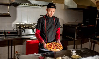Şefin mutfakta taze pizza göstermesi, yemek pişirme konsepti