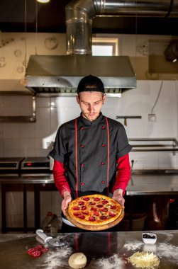 Şefin mutfakta taze pizza göstermesi, yemek pişirme konsepti