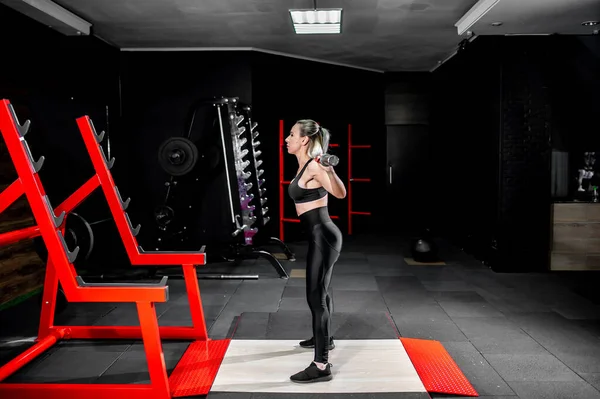 Spor Salonunda Dambıllarla Egzersiz Yapan Genç Bir Kadın — Stok fotoğraf