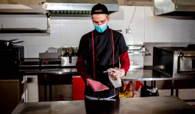 Üniformalı şef restoranda mutfak temizliği yapıyor. 