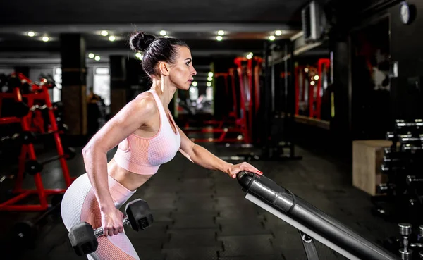 Spor Kıyafetli Genç Bir Kadın Spor Salonunda Dambıllarla Egzersiz Yapıyor — Stok fotoğraf