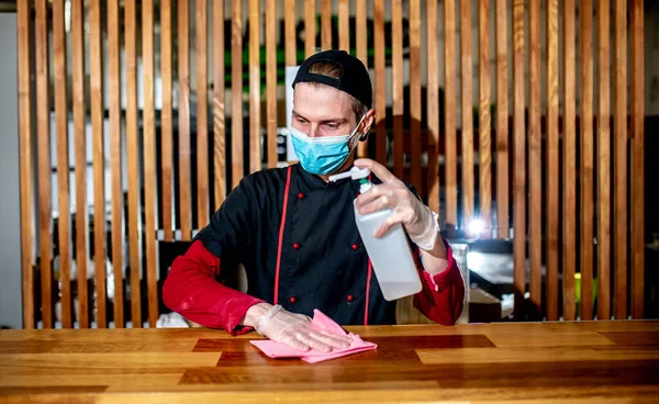 chef in uniform cleaning kitchen at restaurant